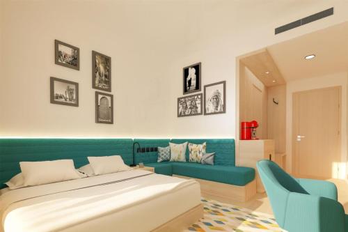 une chambre avec un lit et un canapé bleu dans l'établissement Hampton By Hilton Ben Guerir, à Benguerir