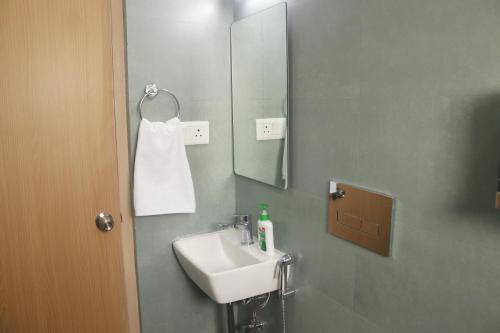 un bagno con lavandino e specchio di Axon Corporate Stays Newtown, Kolkata a kolkata
