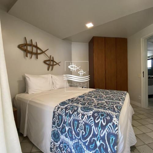 a bedroom with a bed with a blue and white blanket at Jatiúca Suítes Resort - Flat 413 in Maceió