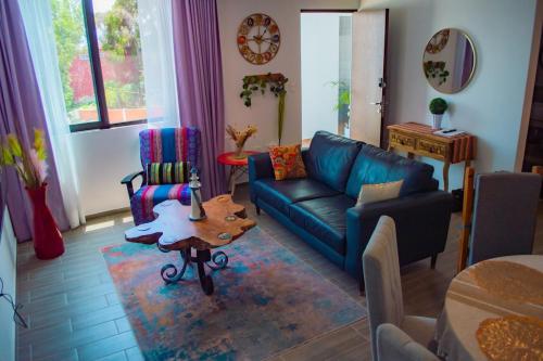 a living room with a blue couch and a table at Full Kitchen, Great View, Historic Center, Quiet in Puebla