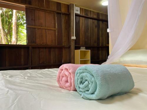 une paire de serviettes assises sur un lit dans l'établissement Moonshine Phayam beach resort & restaurant, à Ranong