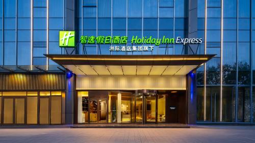 Holiday Inn Express Shenzhen Sports Center by IHG في شنجن: مبنى به لافتة على واجهته