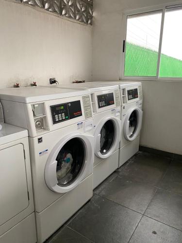 three washing machines in a laundry room with a window at Habitacion C10 privada centro monterrey in Monterrey