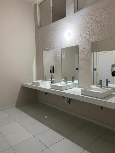 a public bathroom with three sinks and two mirrors at Habitacion C10 privada centro monterrey in Monterrey