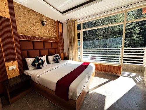 a bedroom with a large bed and a large window at Staynest BNB - Balcony Rooms - 3BHK Apartments in Shimla
