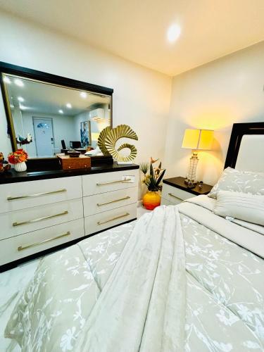 a bedroom with a white bed and a large mirror at Belmont Lux Escape in Elmont