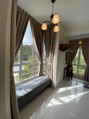 a room with a couch in front of windows at Jo’s Place Cameron Highlands EA922 in Brinchang