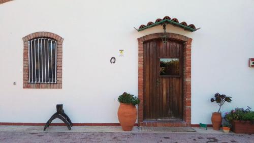 オンニーナにあるFerienhaus Für 12 Personen In Syrakusの木の扉と植物