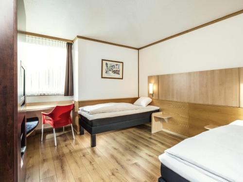 Un dormitorio con una cama, un escritorio y una mesa. en ibis Hotel Eisenach, en Eisenach