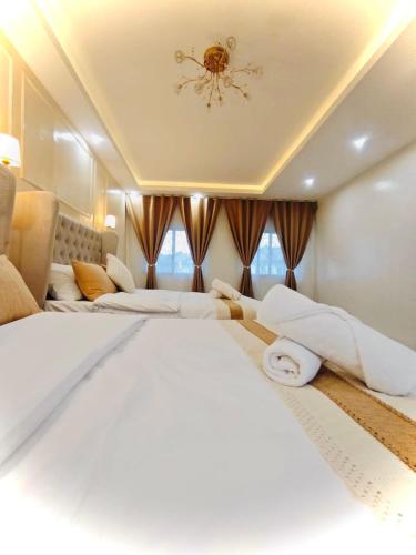 Habitación grande con 2 camas y lámpara de araña. en Kahlua, en Sampong