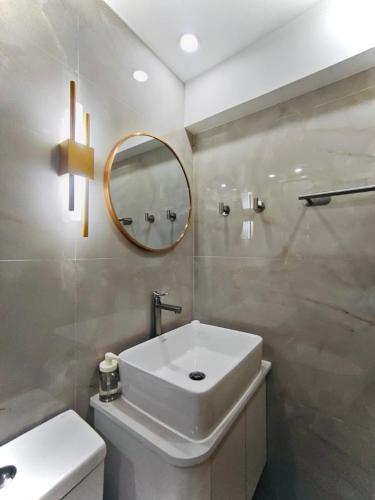 Un baño con un lavabo blanco y un espejo. en Kahlua, en Sampong