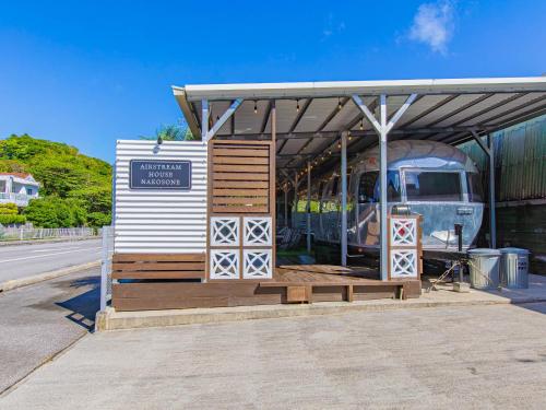 a bus stop with a bus parked under a roof at Air Stream House Nakasone in Nakijin
