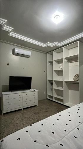 a bedroom with a bed and a dresser with shelves at Família Macapá in Macapá