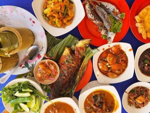 einen Tisch mit Teller mit Lebensmitteln verschiedener Arten in der Unterkunft Ipoh Anderson Condo - 2BR in Ipoh