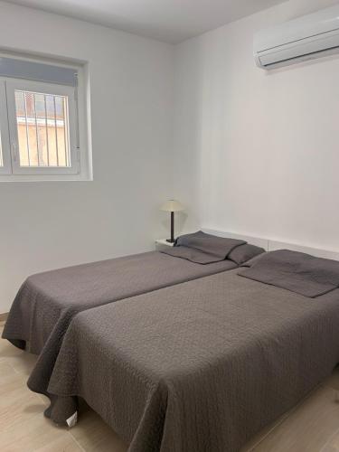 a bed in a white room with a window at Cal Sereno in Agramunt