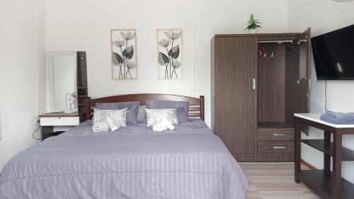 a bedroom with a large bed and a television at B&N House in Nai Yang Beach