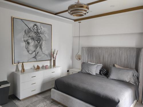 a bedroom with a bed and a painting on the wall at beautiful house near the consulate in Manuel F. Martínez