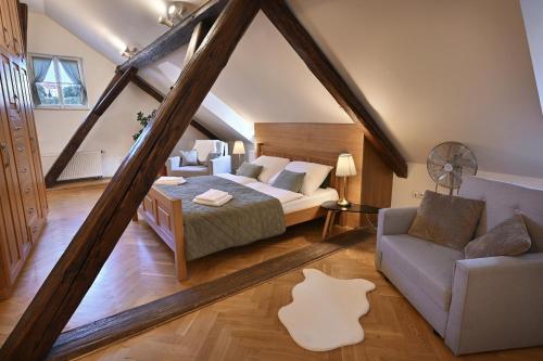 una camera mansardata con letto e divano di White Swan Boutique Apartments a Praga