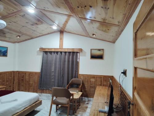 a bedroom with a bed and a desk and a table at Hotel CM Palace - Pure Vegetarian in Ner Chowk