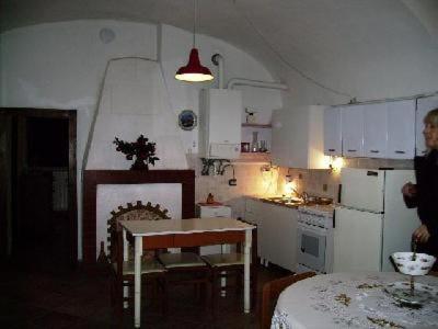 a small kitchen with a table and a table and a person at Wohnung Caprifoglio In Miasino in Miasino