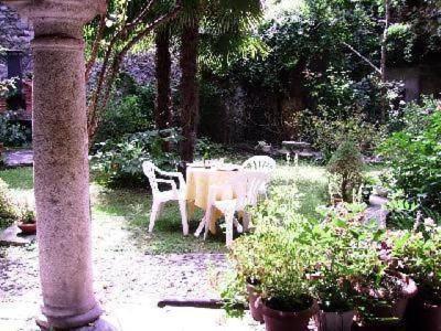 a table and chairs in a garden with plants at Wohnung Caprifoglio In Miasino in Miasino