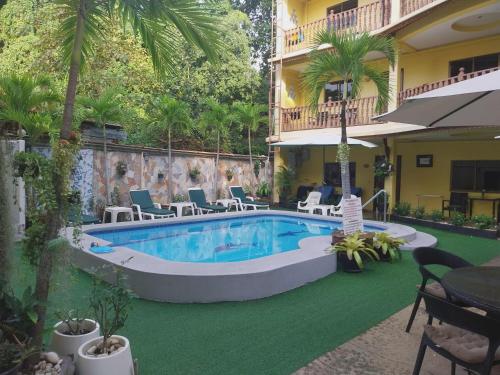 パタヤ・サウスにあるPhratamnak Inn - 100 meter from Beachのスイミングプール(椅子付)、