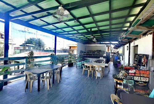 a covered patio with tables and chairs and tablesearcher at Villa Monica Hotel in Balatero