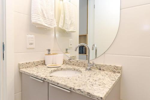 ein Badezimmer mit Waschbecken und Spiegel in der Unterkunft Edifício Smart Home | Gonzaga Stays in Curitiba