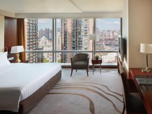 上海市にあるPullman Shanghai Central - In XinTianDi & Yu Garden Areaのベッドと大きな窓があるホテルの部屋