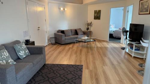 a living room with a couch and a television at Serene Mountain Cabin Retreat Tamborine Mountain in Mount Tamborine