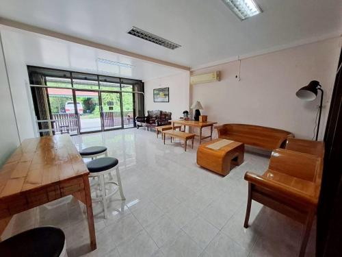 a living room with wooden tables and chairs at Padang Besar In front of Border Private room & Hostel in Sathani Padang Besa