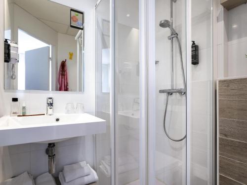 a white bathroom with a sink and a shower at ibis Styles Rennes St. Gregoire in Saint-Grégoire