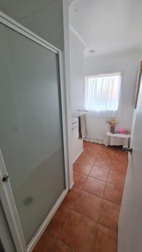 baño con puerta de cristal y suelo de baldosa en Scenic Coastal Gem with Pool, Tennis, Securely Gated, en Whangaparaoa