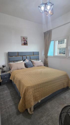 a bedroom with a large bed with a blue headboard at Reem 1 in Ajman 