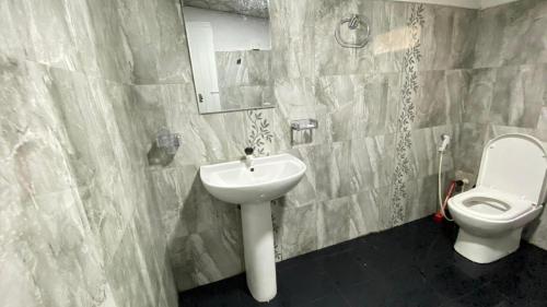 a bathroom with a sink and a toilet at White Cozy Family Bungalow in Badulla
