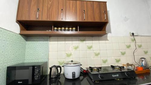 a kitchen counter with a microwave and a coffee maker at White Cozy Family Bungalow in Badulla