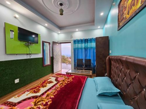 a bedroom with a large bed and a flat screen tv at Hotel Dream House in Kanatal