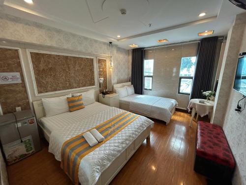 a hotel room with two beds and a table at Jewel Hotel in Ho Chi Minh City