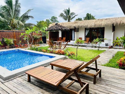 テテバトゥにあるZiraya Villa & Bungalowのリゾートで、プール、テーブル、椅子が備わります。