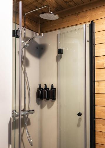 a shower stall with a glass door in a bathroom at Silencius Cabin With Private Jacuzzi in Rovaniemi