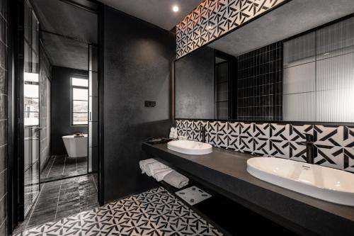 Un baño con dos lavabos y un espejo grande. en 烟台朝阳文保艺术酒店, en Yantai