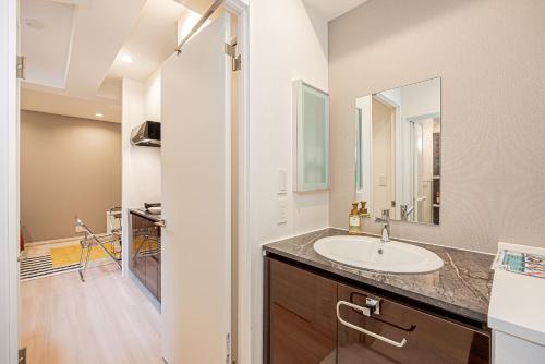 ein Badezimmer mit Waschbecken und Spiegel in der Unterkunft Mi-HOTEL SHIMOKITAZAWA in Tokio