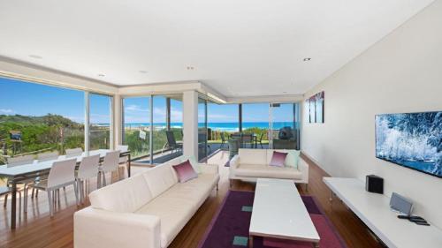 a living room with a couch and a table at The Pavillion 1 - Beachfront in Wamberal