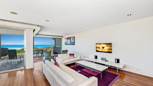 a living room with a couch and a table at The Pavillion 1 - Beachfront in Wamberal