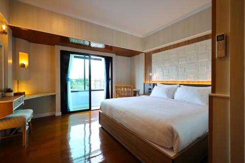 a hotel room with a large bed and a window at Sira Boutique Chiang Mai in Chiang Mai