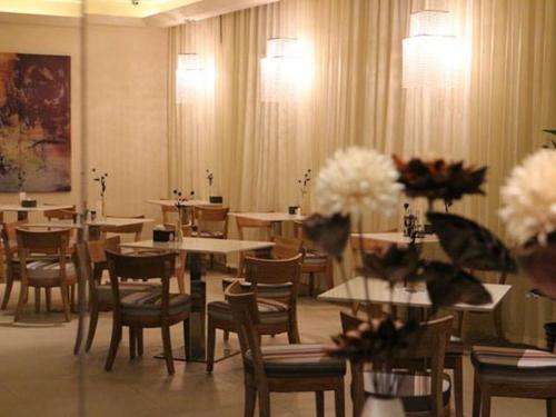 a dining room with tables and chairs and flowers at Jinjiang Inn Select Xining West Wusi Road New Hualian Square in Xining