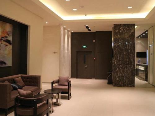 a lobby with a couch and chairs and a table at Jinjiang Inn Select Xining West Wusi Road New Hualian Square in Xining