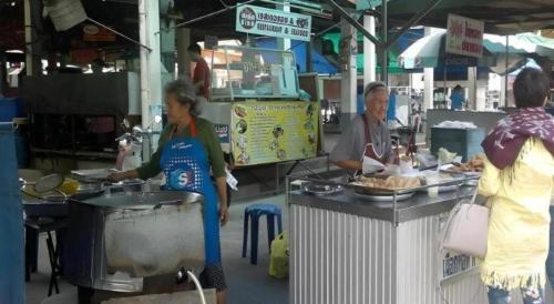 a group of people standing around a food stand at Chevasai Huahin Hotel in Hua Hin