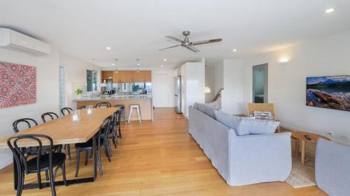 a dining room and living room with a table and a couch at Point View - 'amazing Views =& Location=' in Avoca Beach