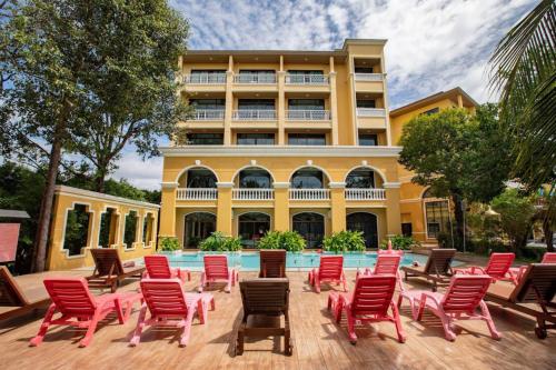 クラビタウンにあるThe Pineapple Hotelの建物の前の赤い椅子とプール